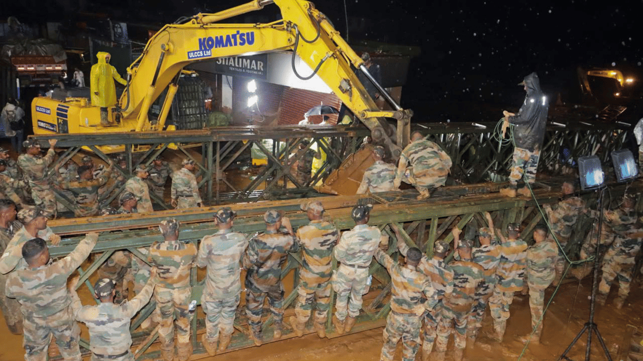 കണ്ണൂർ പ്രതിരോധ സുരക്ഷാസേന (ഡി എസ് സി)യിലെ ക്യാപ്റ്റൻ പുരൻ സിങ് നഥാവതിൻ്റെ നേതൃത്വത്തിലാണ് പാലത്തിൻ്റെ നിർമ്മാണ പ്രവർത്തനം. 17 ട്രക്കുകളിലായാണ് പാലം നിർമ്മാണത്തിൻറെ സാമഗ്രികൾ ഇന്നലെ വയനാട്ടിലെ ദുരന്തഭൂമിയിലേക്ക് എത്തിച്ചത്. 195 അടി നീളമുള്ള ബെയ്‌ലി പാലമാണ് വയനാട്ടിൽ സൈന്യം ഉപയോഗിക്കുന്നത്. 110 അടി നീളവും 50 ടൺ ഭാരമുള്ള ബെയ്‍ലി പാലമാണ് സാധാരണയായി രക്ഷാപ്രവർത്തനത്തിനായി നിർമ്മിക്കാറുള്ളത്. എന്നാൽ വയനാട്ടിലാകട്ടെ 180 അടി നീളത്തിൽ പാലം വേണ്ടതുണ്ട്.  (IMAGE CREDITS: PTI)