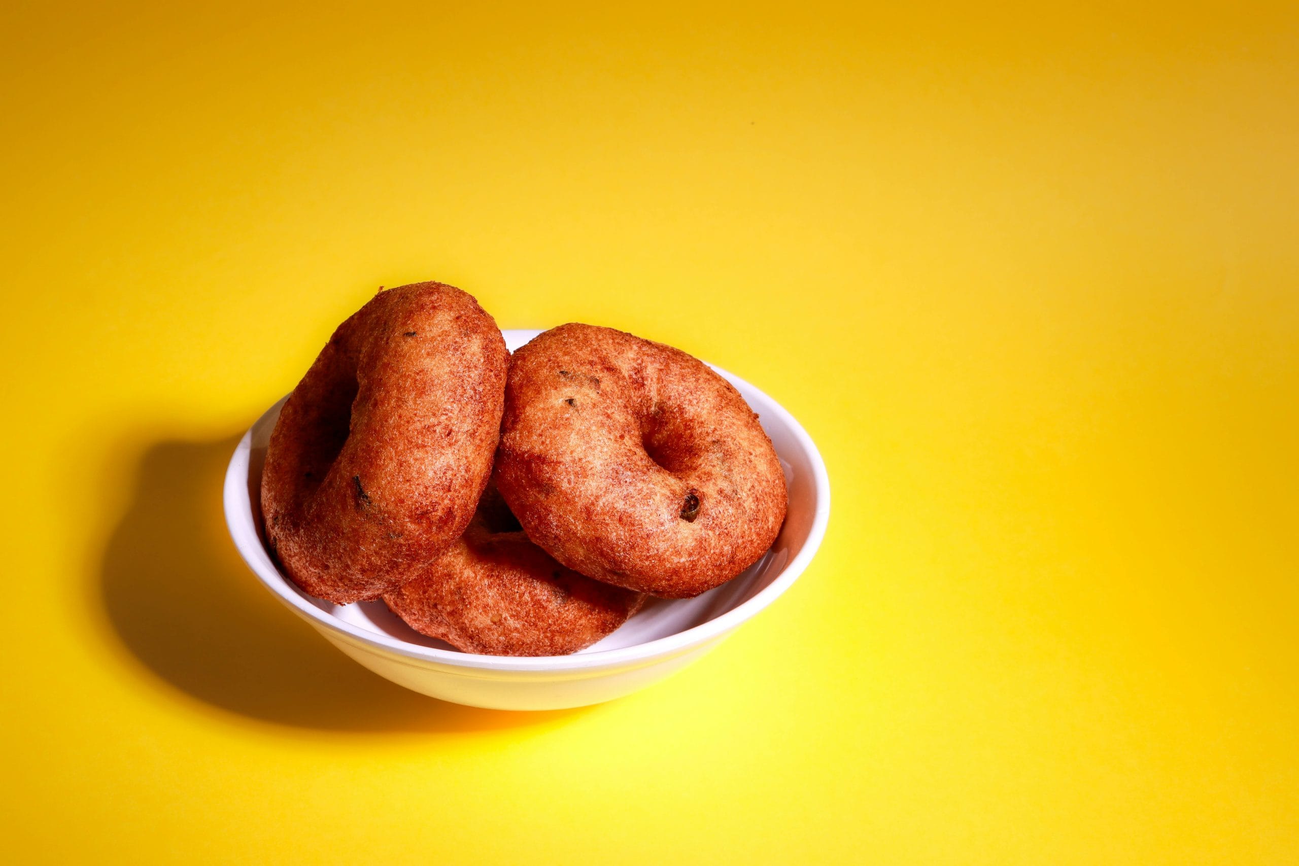 ഇനി അതിന്റെ ഉൾവശം പാകമാകുന്നത് വരെ കാത്തിരിക്കാനും കഴിയില്ല, കാരണം അപ്പോഴേക്കും പുറം ഭാഗം മുഴുവൻ കരിഞ്ഞു പോകും. ഈ അവസ്ഥ ഒഴിവാക്കാൻ വേണ്ടിയാണ് ഉഴുന്ന് വടയ്ക്ക് നടുവിലായി തുളയിടുന്നത്. കൂടാതെ വടയിലെ ഇത് അധിക എണ്ണ എളുപ്പത്തിൽ കളയാൻ അനുവദിക്കുന്നു. (Image Credits: Unsplash/Pexels)  
