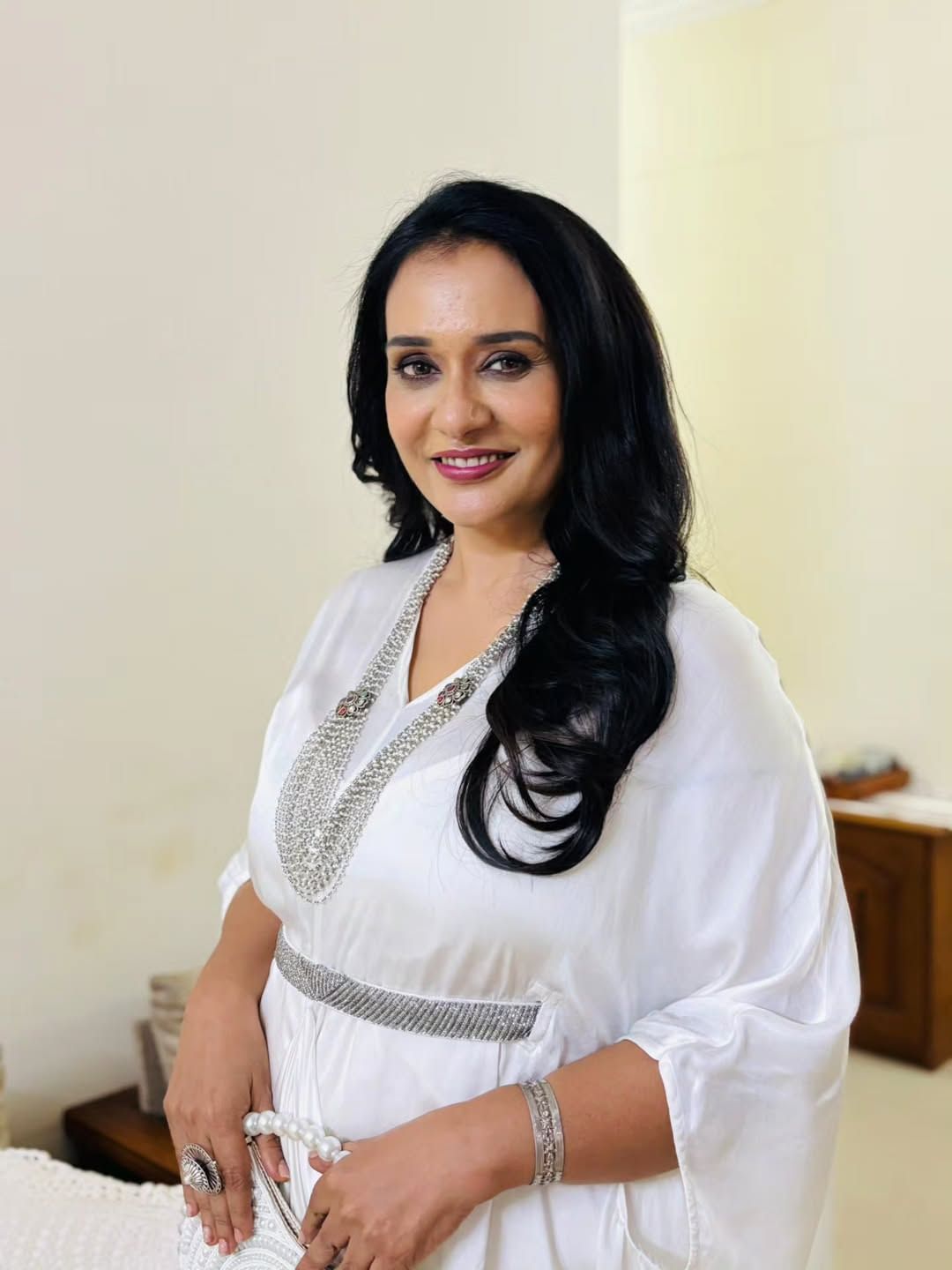 വെള്ളനിറത്തിലുള്ള ഒരു ഗൗണ്‍ ആണ് താരം ധരിച്ചിരിക്കുന്നത്. ഇതിനു ചേരുന്ന സില്‍വര്‍ നിറത്തിലുള്ള ലെയേര്‍ഡ് മാലയും വളയും വലിയ മോതിരവുമാണ് ആഭരണമായി അണിഞ്ഞത്. വെള്ളനിറത്തിലുള്ള മുത്തുകള്‍ പിടിപ്പിച്ച റൗണ്ട് ക്ലച്ച് ബാഗും ഔട്ട്ഫിറ്റിന്റെ ഭംഗി കൂട്ടുന്നു.