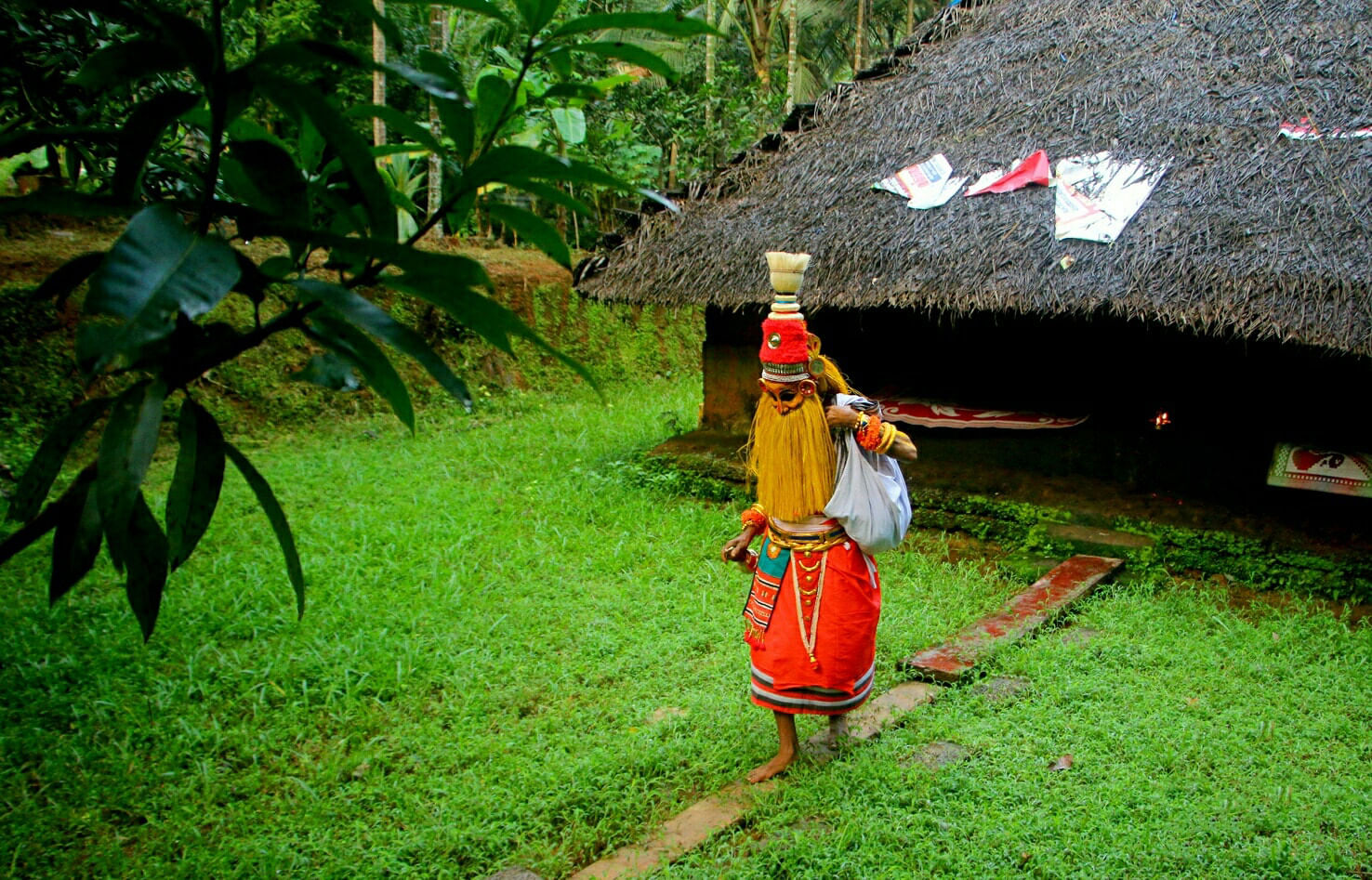 മുഖത്ത് ചായവും കുരുത്തോലക്കുടയും കൈതനാരുകൊണ്ട് തലമുടിയും കിരീടവും, കൈവളയും എന്നിങ്ങനെ വളരെ വ്യത്യസ്തമാർന്ന വേഷമാണ് ഓണപ്പൊട്ടൻ്റേത്. കൂടാതെ മറ്റ് തെയ്യങ്ങളെ അപേക്ഷിച്ച് പ്രത്യേകരീതിയിലുള്ള ഉടുപ്പാണ് ഇവര് ധരിക്കാറ്. ഓണപ്പൊട്ടൻ ഒരിക്കലും കാൽ നിലത്തുറപ്പിക്കില്ല. കാരണം എപ്പോഴും താളം ചവിട്ടുകയും ഓടുകയും ചെയ്തുകൊണ്ടേയിരിക്കും. ദക്ഷിണയായി അരിയും പണവുമാണ് സാധാരണയായി വീടുകളിൽ നിന്ന് കൊടുക്കുന്നത്. ഓണപ്പൊട്ടനും മണിയൊച്ചയുമാണ് മലബാറുകരുടെ ഓണം വരവറിയിക്കുന്നത്. (Image Credits: Social Media/ PTI)
