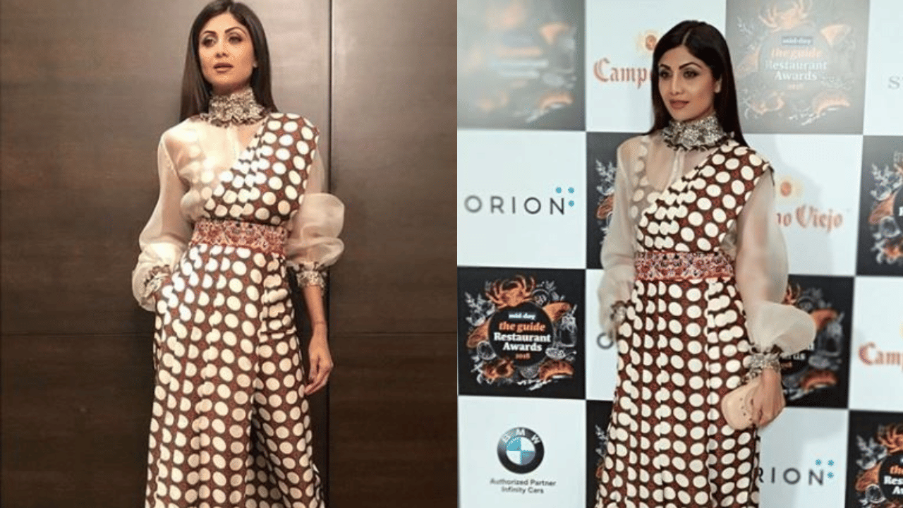 ശിൽപ ഷെട്ടിയുടെ ജമ്പ്സ്യൂട്ട് സ്റ്റൈൽ സാരി ഡ്രേപ്പ് ലുക്കും പരീക്ഷിക്കാം. ബ്രൗൺ, വൈറ്റ് പോൾക്ക ഡോട്ട് ഹാഫ്-ഡ്രേപ്പ്ഡ് സാരി, ഷീർ ഫാബ്രിക്കിലുള്ള ബിഷപ്പ് സ്ലീവ്‌ഡ് വൈറ്റ് ബ്ലൗസിനൊപ്പം ധരിക്കാം. കൂടെ ജമ്പ്സ്യൂട്ടിന്റെ പോൾക്ക ഡോട്ട് പ്രിന്റ് കാണുന്നത് ആകർഷകമായ ലുക്ക് നൽകുന്നു. (Image Credit: Social Media)