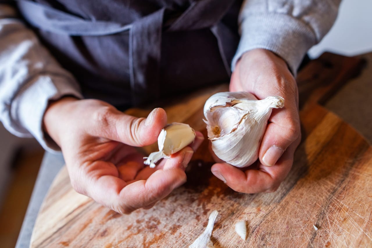 അടുക്കളയിലെ ഏറ്റവും ബുദ്ധിമുട്ടേറിയ പണി ഏതാണെന്ന് ചോദിച്ചാൽ മിക്ക വീട്ടമ്മമാരുടെയും ഉത്തരം ഒന്നായിരിക്കും... വെളുത്തുള്ളിയുടെ തൊലി കളയുക! ഈ പണിയോടുള്ള മടി കാരണം കറികളിൽ വെളുത്തുള്ളി കുറയ്ക്കുന്നവർ പോലും നമ്മുക്കിടയിലുണ്ട്. കറികളിലും അച്ചാറുകളിലും വെളുത്തുള്ളിയുടെ രുചി ഒഴിച്ചുകൂടാനാവാത്തതാണ്, എന്നാൽ അത് നന്നാക്കിയെടുക്കാൻ എടുക്കുന്ന സമയം ആലോചിക്കുമ്പോഴാണ് പലരും കുഴങ്ങുന്നത്. (Image Credits: Getty Images)
