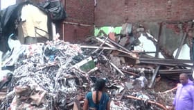 കനത്ത മഴ: നാലുനിലക്കെട്ടിടം വീടിന് മുകളിൽ വീണ് അഞ്ചുപേർ മരിച്ചു