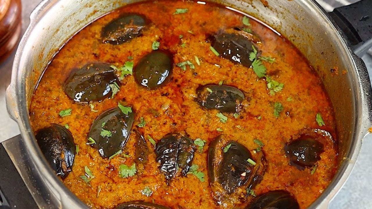 ഇതിലേക്ക് ചെറിയ ഉള്ളിയും അരിഞ്ഞു വെച്ച വഴുതനങ്ങയും ചേർത്ത് ഒരു മിനിറ്റ് നന്നായി വഴറ്റുക. തയ്യാറാക്കി വച്ചിരിക്കുന്ന മസാല പേസ്റ്റ് ഇതിലേക്ക് ചേർത്ത് നന്നായി ഇളക്കുക. ശേഷം ആവശ്യത്തിന് വെള്ളവും ഉപ്പും മഞ്ഞൾപ്പൊടിയും ചേർത്ത് വഴുതനങ്ങ വെന്ത് വരുന്നവരെ ഇടത്തരം തീയിൽ തിളപ്പിക്കുക.